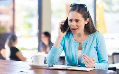 Woman making angry phone call in local coffee shop