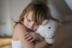 Sad girl hugging a stuffed animal