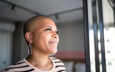 Woman with bipolar disorder looking out window.