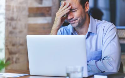 man looking stressed at computer