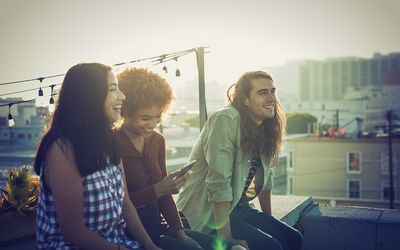 A throuple sharing a laugh on urban rooftop