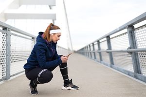 Young happy woman exercising on the modern bridge.