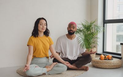 The guy doesn't really want to meditate and looks at his girlfriend with the thought that it' time to finish