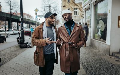 A gay couple walking down the street after meeting each other on a dating app, on their way to eat some food.