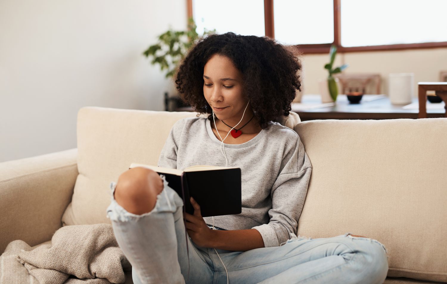 Woman writing in her journal on the couch.