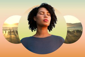 Woman closing her eyes against a mountain backdrop