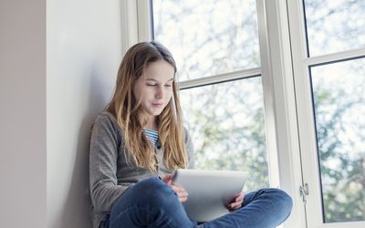 Candid Portrait of a Twelve Year Old Girl Using a Digital Tablet for Online Therapy.