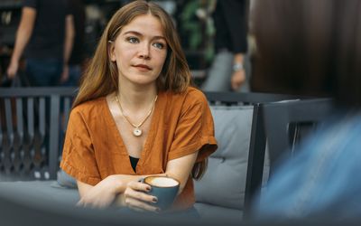 Concerned young woman talks with friend in coffee shop