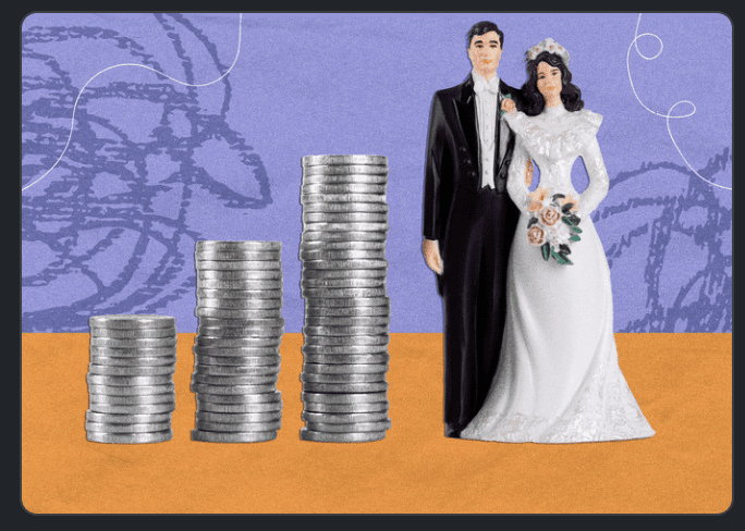 A man and a woman embracing one another, as they stand next to columns of quarters. 