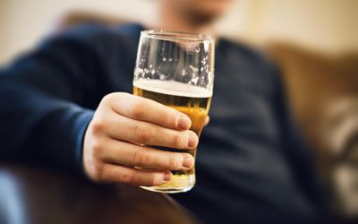 man holding glass of beer