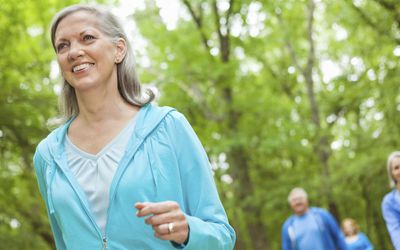 Mature smiling woman walking in a park