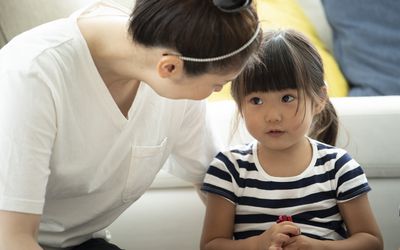 Mother talking to her daughter on the floor