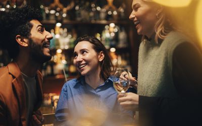 3 friends talking at a bar