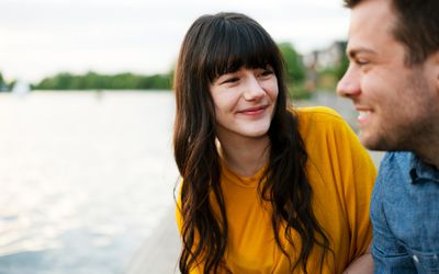 Woman looking at man, smiling. Both of them enjoying hanging out with each other
