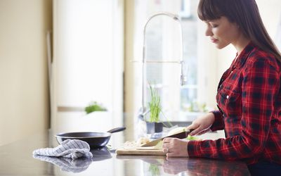 woman cutting onion on kitchen counter