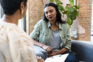 Young woman focuses on female counselor's advice