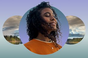 Woman smiling with eyes closed meditating against a mountain backdrop