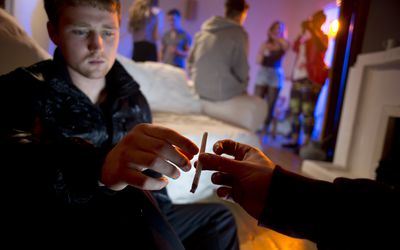 Young man hesitating to accept a joint at a house party