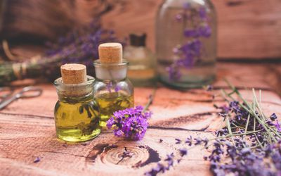 Fresh lavender oil with fresh flowers on wooden background