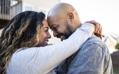 Husband and wife in front of home