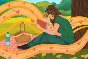 woman reading on a picnic blanket at the park