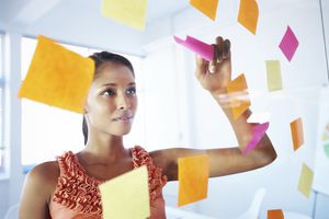 woman looking at sticky notes on glass wall