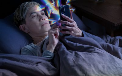 Older person on their phone in bed