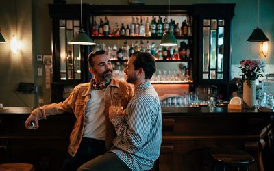 gay couple sitting in a bar