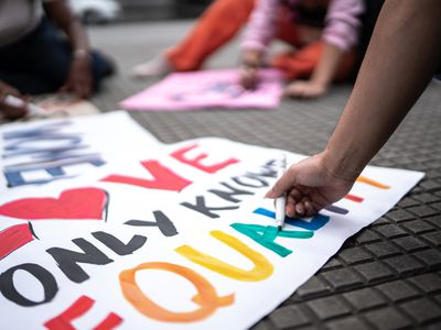 Woman's hands writing in posters before a protest in the street - stock photo