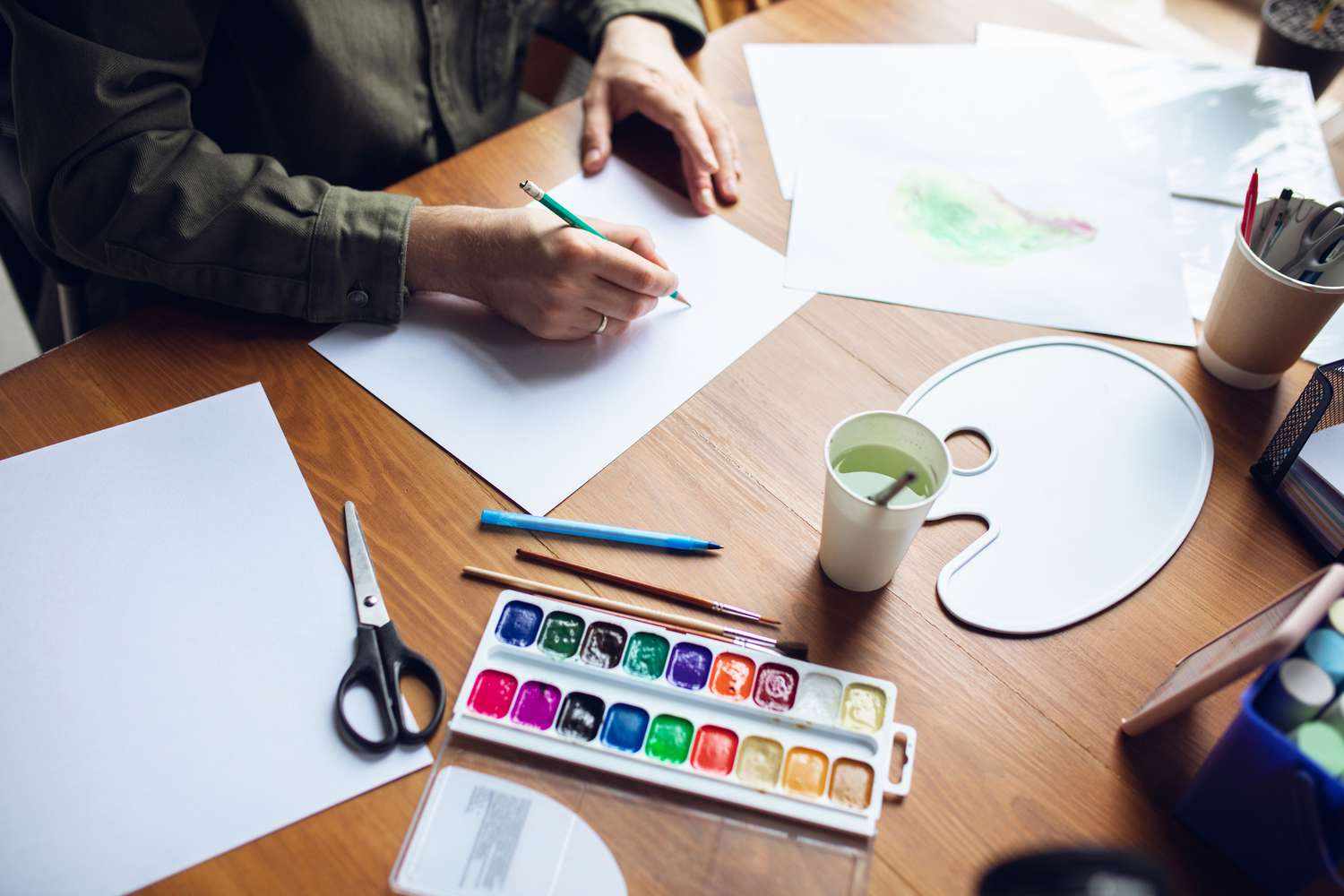 Man drawing with paints and pencils as part of expressive art therapy