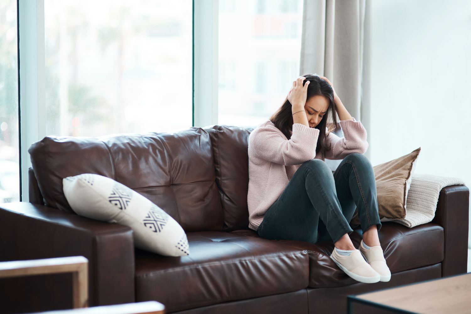 Shot of a young woman experiencing mental anguish at home