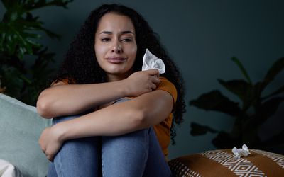 Shot of a young woman feeling unhappy at home