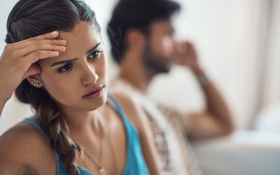 Shot of a young couple having an argument while sitting on their couch at home