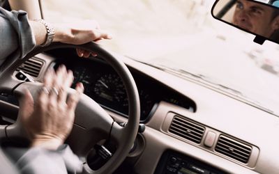 Man honking horn on motorway with frustrated expression (blurred motio