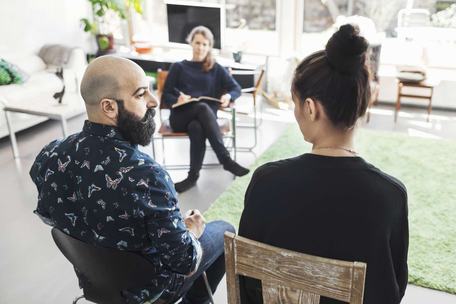 male and female sitting across from a therapist in her office