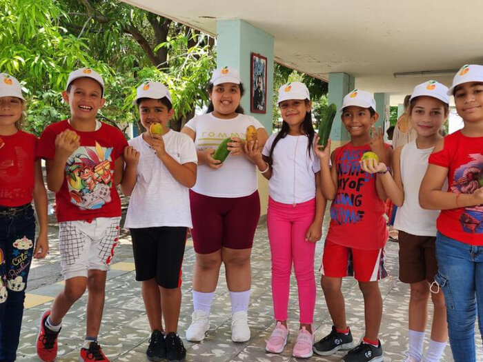 Students at a primary school in Jiguaní, Granma, pose with fresh vegetables and fruits that they receive weekly through the “Actúa diferente” project. As part of the project, with funds of the Korea International Cooperation Agency (KOICA), the students also receive training to improve their food and nutrition education.