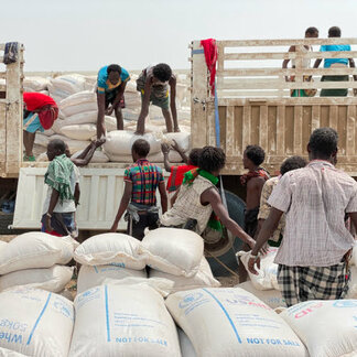 Men offloading nutritious food assistance provided by WFP