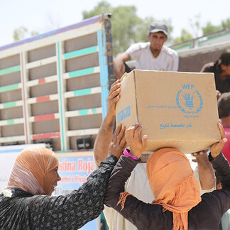 Women receiving food assistance from WFP in response to food insecurity in Syria