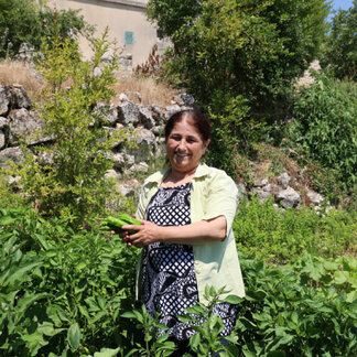 A woman with crops from her farm, beneficiary of resilience projects organized by WFP in Syria