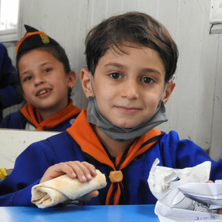 School children receiving fortified snacks from WFP to improve health and motivate families to send children to school.