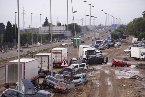 Cars are strewn on the side on a main road after floods in Valencia, Spain, Friday, Nov. 1, 2024. (AP Photo/Alberto Saiz)