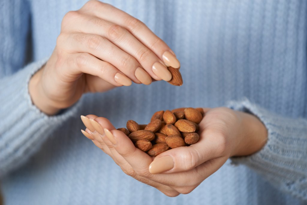 closeup of woman holding almonds