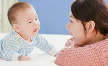 Mother talking to her infant during tummy time