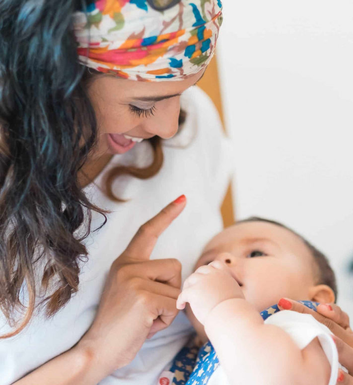 Mother holding infant and smiling