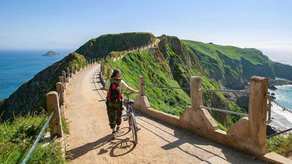 Woman wheeling a bike on Sark Island