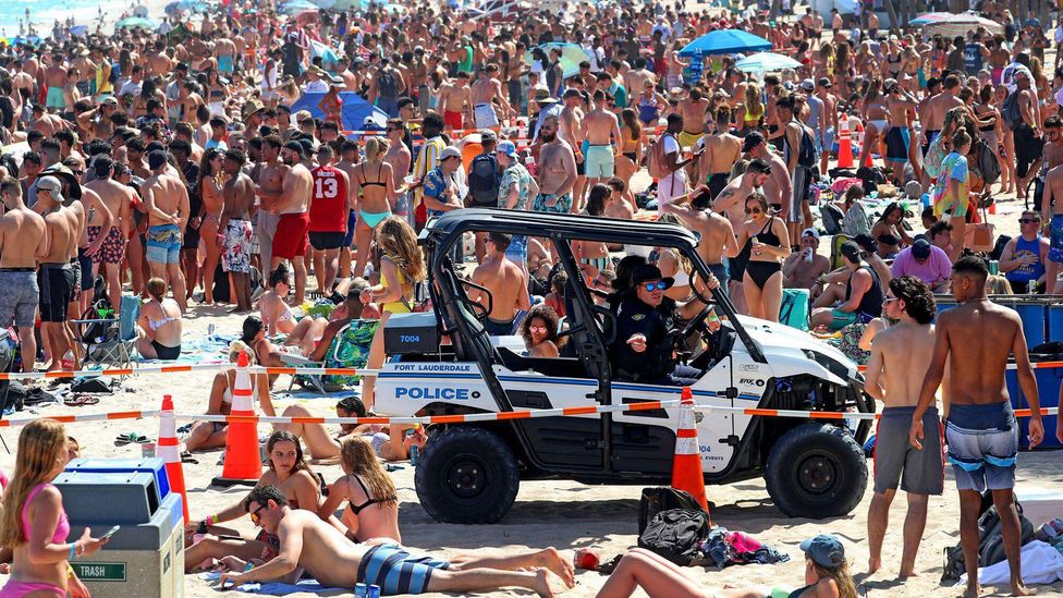 Spring breakers on beach in Florida with police